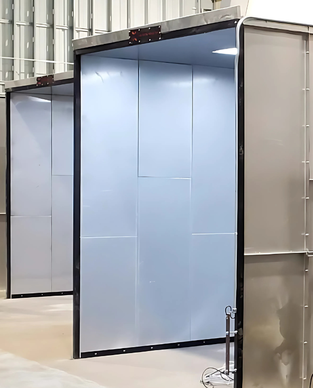 Industrial powder coating booths with open entrances inside a manufacturing facility.