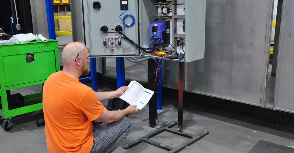 Technician troubleshooting an industrial electrical panel in a manufacturing facility.

